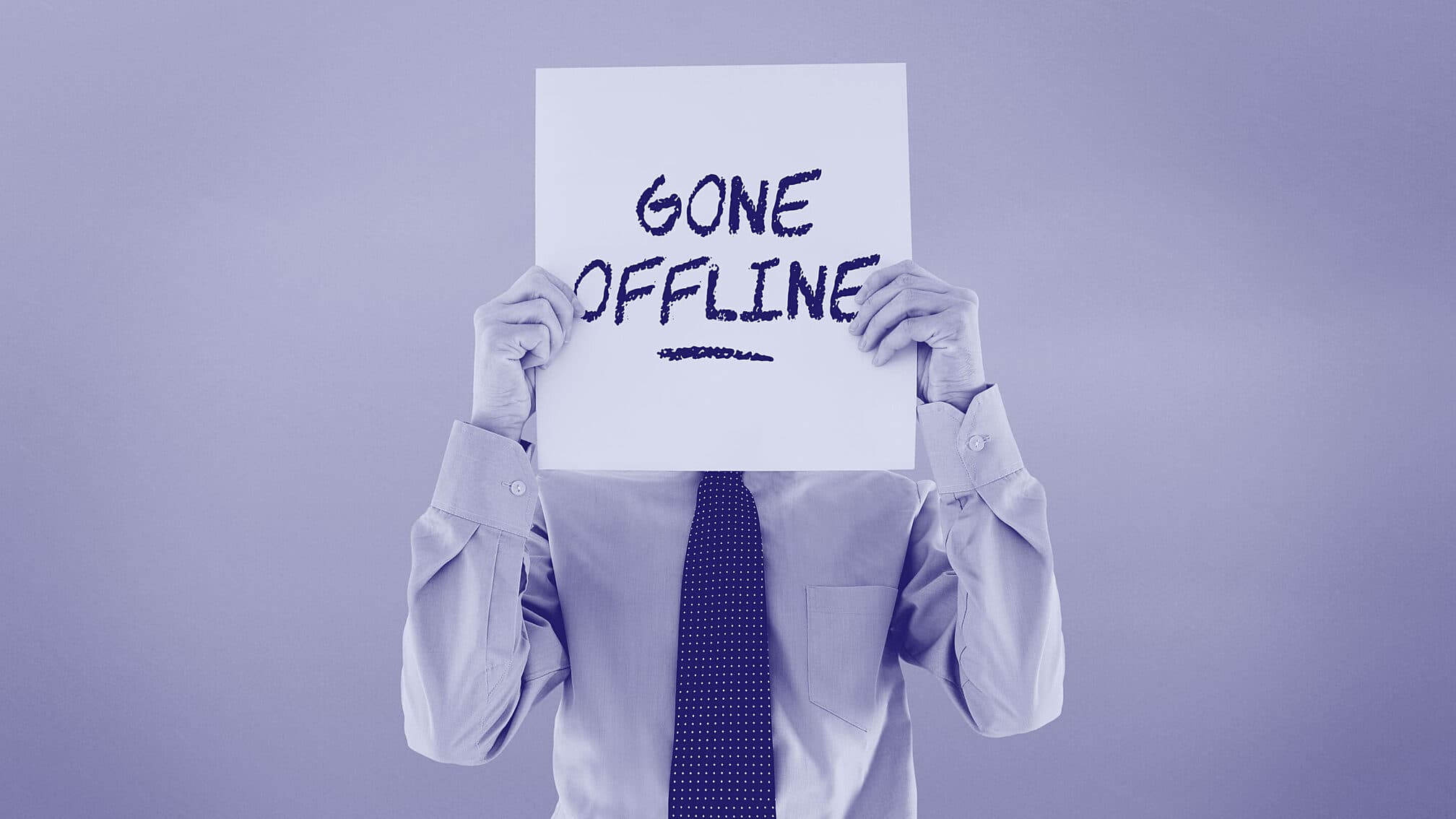 Business executive holding sign in front of face that says gone offline.